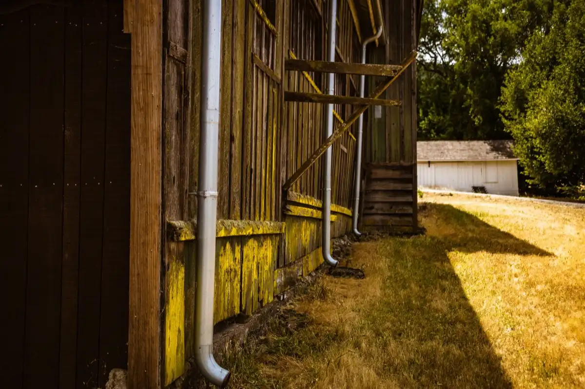 Roof edge, fascia and downspout on a house in Portland, ME, where drip edge carries runoff into the gutter